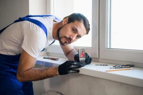 The fitter uses the level on the windowsill Stock Photos