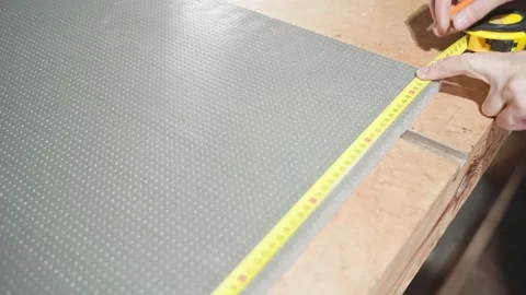 Fitting gray foam insulation to size with a tape measure and pencil Stock Footage 169694830