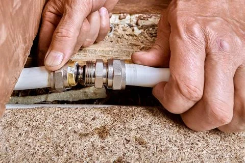 Fitting installation joins two multilayer pipes as insert slides into pipe .. Foto stock