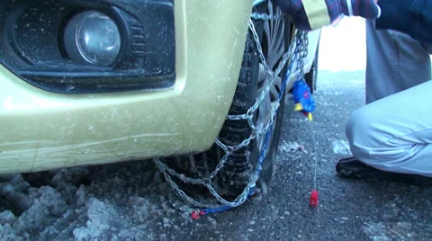 Fitting snow chains on car wheel 1 Video stock 33071735