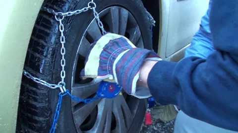 Fitting snow chains on car wheel 2 Stock Footage 33072479