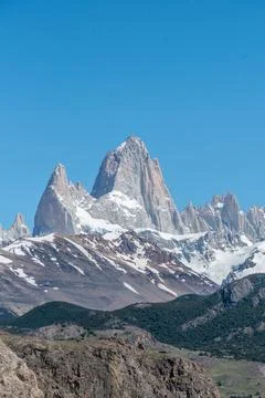 The Fitz Roy mountain range is covered in snow and the sky is clear and blue Foto stock
