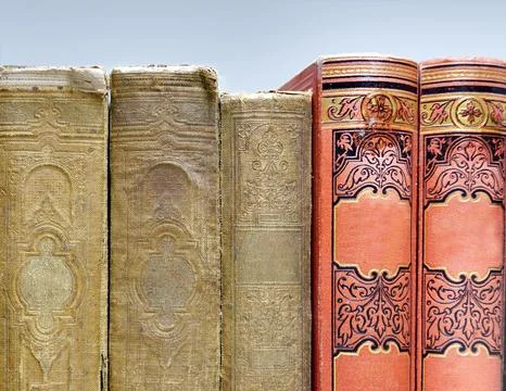 Five antique books with textile binding on the bookshelf Stock Photos