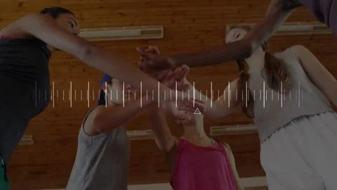 Five athletes reaching inward, stacking hands for unity under wood ceiling, Stock Footage 320916188