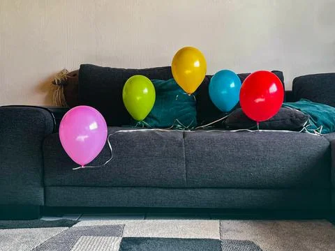 Five balloons on the couch Stock Photos