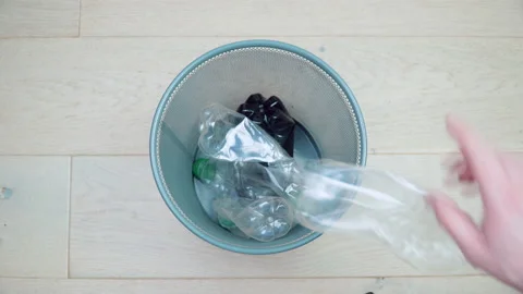 Five bent plastic bottles fall into an empty trash can. Sorting and processing 库存影片 151769182