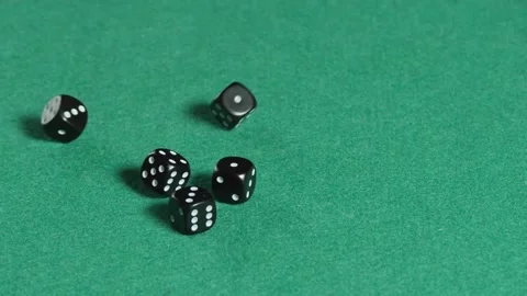 Five black dices rolling in slow motion on a green mat Stock Footage 161955428