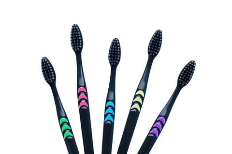 Five black toothbrushes with carbon soft bristles close-up. White isolate Stock Photos