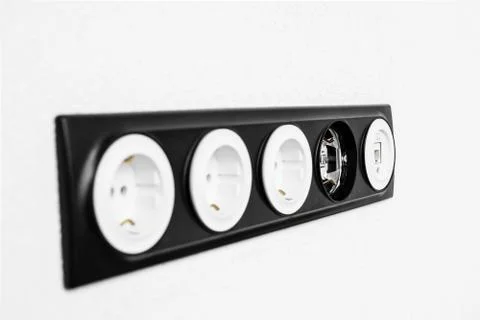 Five black white sockets in the white wall Фото