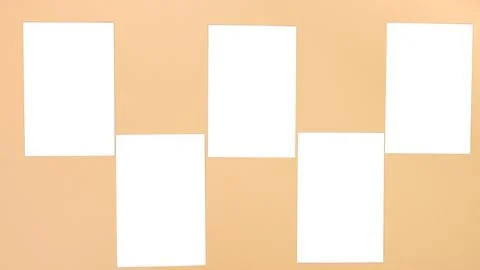 Five Blank White Paper Sheets Arranged on a Beige Wall for Creative Mockups and Stock Photos