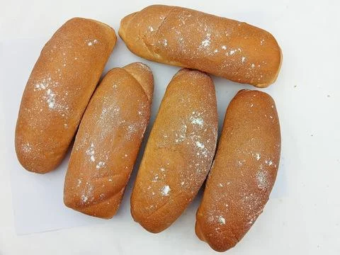 Five bread rolls sprinkled with flour on white background Stock Photos