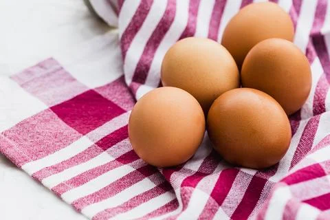 Five brown eggs on a red checkered cloth, copy space. Stock Photos