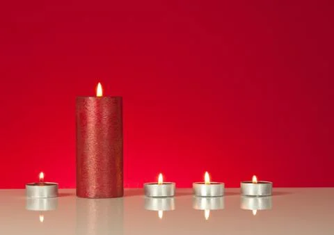 Five burning candles over red background Stock Photos