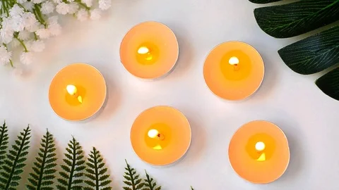 Five burning candles on white background top view Stock Footage 119203117