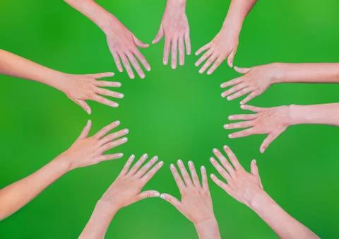 Five children hands joining in circle above green background Stock Photos