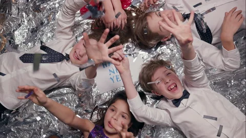 Five Children Lie On Shiny Surface. Celebration. They Are Having Fun. Sequins Stock Footage 180138703