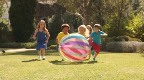 Five children pushing beach ball towards camera in park. Stock Footage 43673109