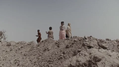 Five children of slaves walk through the territory of a brick factory in Stock Footage 161669624