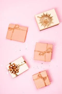 Five Christmas craft gift boxes with glitter on pink pastel background. Stock Photos