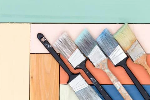 Five cleaned used paintbrushes on stained wood Stock Photos