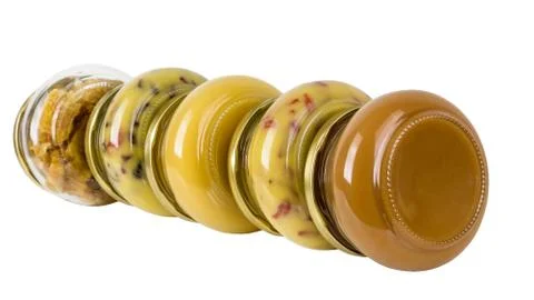 Five closed cans with different honey Stock Photos