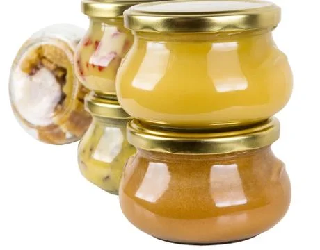Five closed cans with different honey Stock Photos