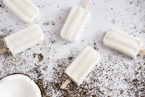 Five coconut yogurt popsicles on a table Stock Photos