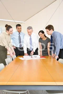 Five colleagues around a desk Stock Photos