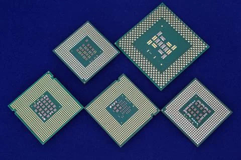 Five computer chips on the blue background. Closeup. Stock Photos