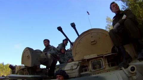 Five crew members are sitting on a moving Terminator-2 tank support combat Stock Footage 170864929