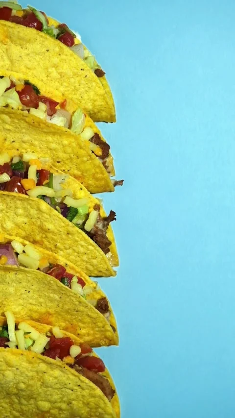 Five crunchy beef tacos arranged on light blue background Stock Footage 331780950