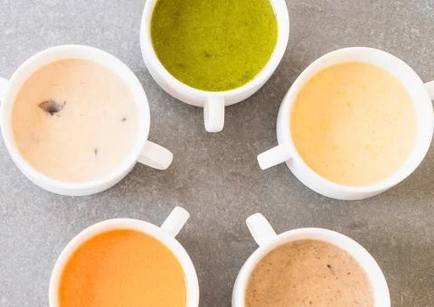 Five cups of different colored creamy sauces arranged in a circle Stock Photos