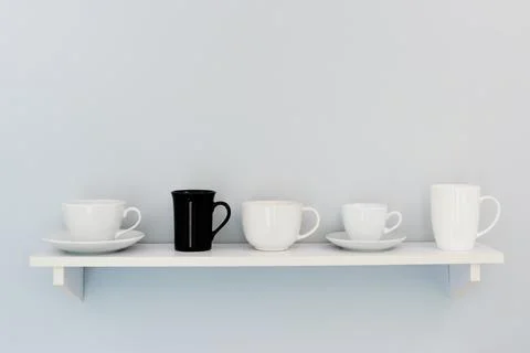Five cups stand on a white shelf Stock Photos