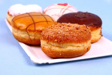 Five delicious, assorted donuts on plate Stock Photos