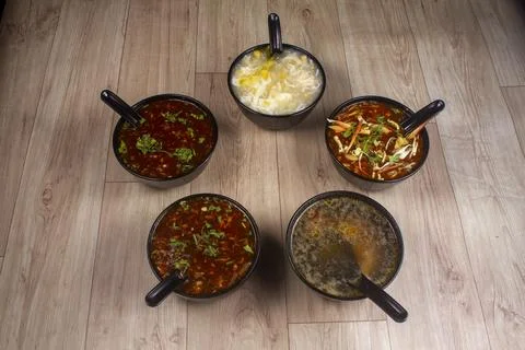 Five different chicken soups in black bowl on wooden background. Stock-Fotos