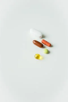 Five different colorful pills, tablets and capsules close up on white backg.. Stock Photos