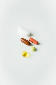 Five different colorful pills, tablets and capsules close up on white backg.. Stock Photos