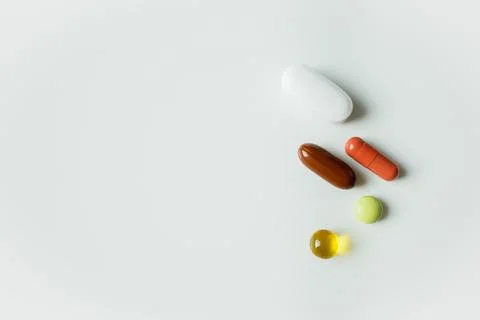 Five different colorful pills, tablets and capsules close up on white backg.. Stock Photos