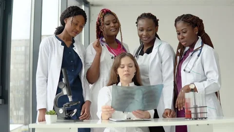 Five doctors of different races examine an X-ray while standing at a table 스톡 동영상 148239308