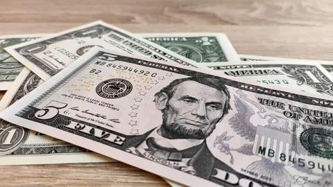 Five dollar bill with bokeh on desktop surface Stock Photos