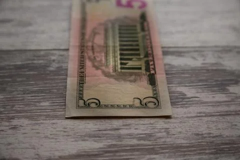 A five-dollar bill on a worn table close-up Foto stock