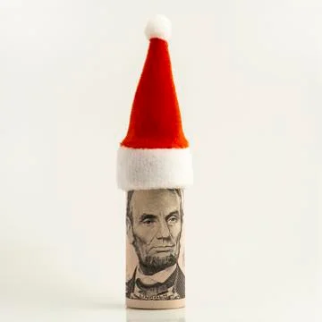 A five-dollar US bill is rolled into a tube and a red cap at the top. Preside Stock Photos