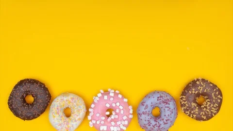 Five donuts spinning in circle and moving to the bottom, leaving copy space Stock Footage 128922687