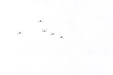 Five drones fly through the air. Drones on a background of gray sky. Unmanned Stock Photos