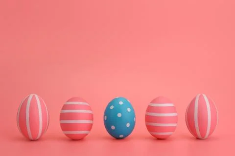 Five Easter blue and pink eggs with white stripes on pink background. Stock Photos