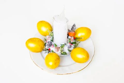 Five easter eggs and white candle on the table Stock Photos