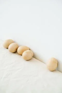 Five Easter eggs trendy pastel colored with cracked shells on a white table a Stock Photos