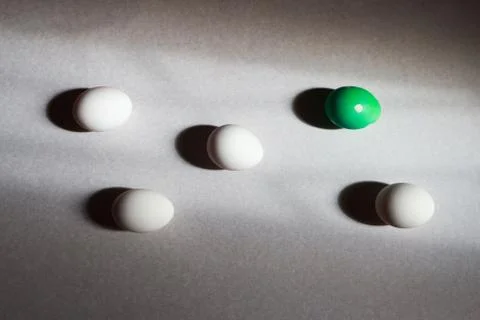 Five eggs in hard light one decorated among others Stock Photos