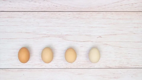 Five eggs pulsing stop motion, animation on white wooden background, top view Stock Footage 128926568