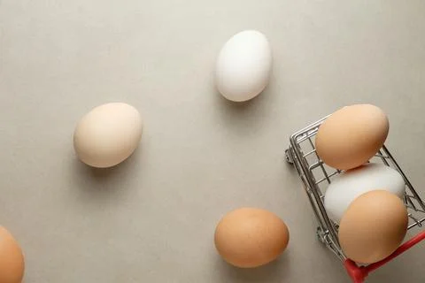Five eggs spread out on a clean surface with a small cart nearby Stock Photos